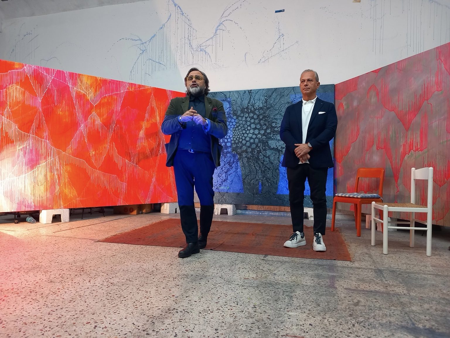 Francesco Cascino e Massimo Maggio durante un Art Talk, davanti a grandi opere colorate